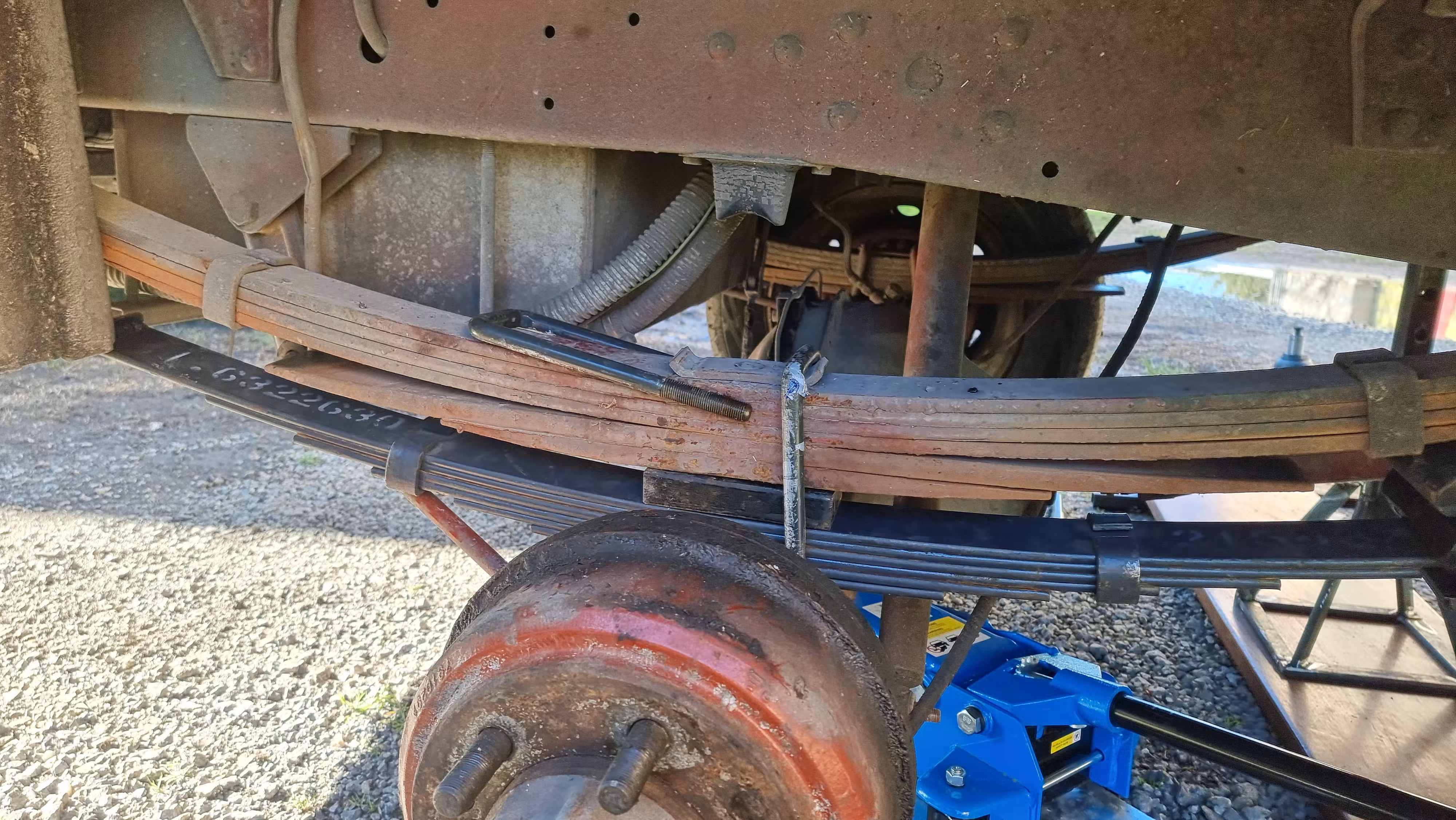 Auxiliary spring inserted by temporarily removing a U-bolt
